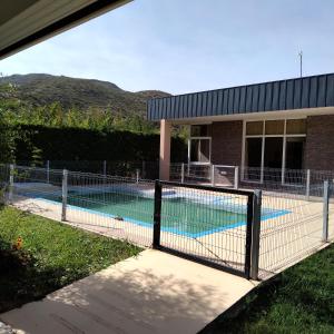 una valla alrededor de una piscina frente a un edificio en El cerro en Valle Grande