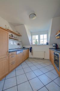 a large kitchen with wooden cabinets and a tile floor at Ferienwohnung Panorama Moselblick in Treis-Karden