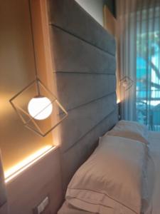 1 dormitorio con 1 cama con cabecero y luz en Park Hotel Morigi Garden & Spa, en Gatteo a Mare