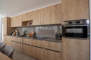 a kitchen with wooden cabinets and a stove top oven at Villa Yolo Luxe Norte Private Pool Corralejo By Holidays Home in Corralejo