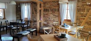 a restaurant with tables and chairs and a brick wall at Ferienhof Idyll am kleinen Fließ in Burg