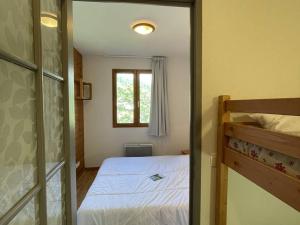 um pequeno quarto com uma cama e uma janela em Appartement Puy-Saint-Vincent, 2 pièces, 6 personnes - FR-1-330G-133 em Puy-Saint-Vincent