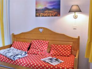 ein Bett mit roten und weißen Polka-Punktkissen in der Unterkunft Appartement Risoul, 2 pièces, 6 personnes - FR-1-330-544 in Risoul