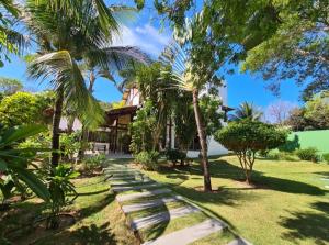 Un jardín con palmeras y una casa. en Villa Francesco, en Pipa
