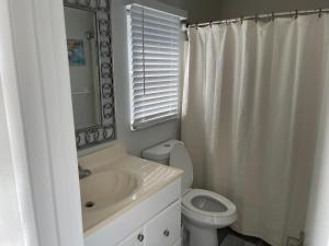 y baño con lavabo, aseo y espejo. en Walk To Siesta Beach, Restaurants, Shopping & More!, en Sarasota