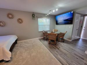 um quarto com uma mesa e uma televisão na parede em Walk To Siesta Beach, Restaurants, Shopping & More! em Sarasota