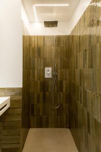 ein Bad mit einer Dusche und Holzfliesen in der Unterkunft CinqueStanze Affittacamere in Messina