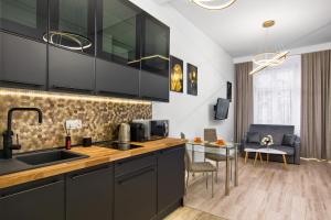 a kitchen with black cabinets and a table with chairs at Silver Shine jacuzzi in Krakow