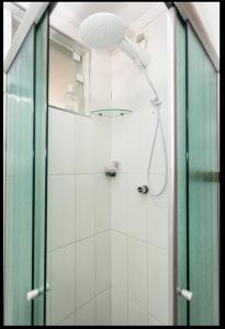 a bathroom with a shower with a glass door at Apartamento compartilhado, no Gonzaga em Santos in Santos