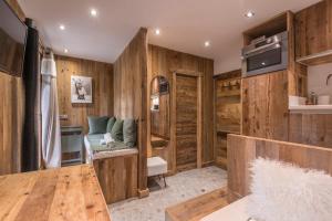 Habitación con paredes de madera, mesa y TV. en Studio Cristallin - Welkeys en Megève