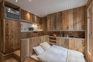 1 dormitorio con paredes revestidas de madera y 1 cama en Studio Cristallin - Welkeys en Megève