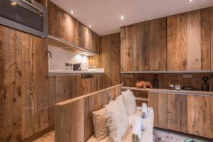 sala de estar con paredes de madera y sofá blanco en Studio Cristallin - Welkeys en Megève