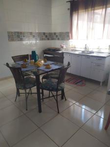 uma cozinha com mesa e cadeiras e uma cozinha com lavatório em Casa Viva Bonito em Bonito