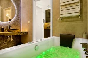 een badkamer met een bad gevuld met groene algen bij Silver Shine jacuzzi in Krakau