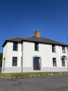 Biały dom z czarnym dachem w obiekcie No 10 Coastguard Station w mieście Renvyle