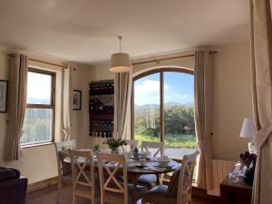 a dining room with a table and chairs and a window at No 10 Coastguard Station in Renvyle