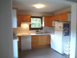 - une cuisine avec des placards en bois et un réfrigérateur blanc dans l'établissement Appartement Arêches-Beaufort, 4 pièces, 9 personnes - FR-1-342-222, à Beaufort