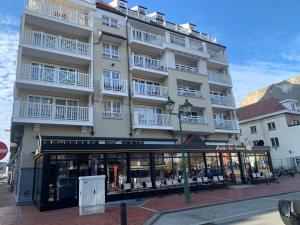 Un gran edificio con balcones blancos en una calle. en Mainstreet Knokke, en Knokke-Heist