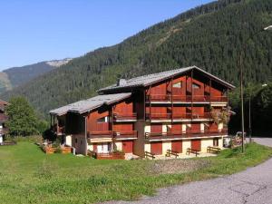 un gran edificio con bancos frente a una montaña en Studio Arêches-Beaufort, 2 pièces, 5 personnes - FR-1-342-247, en Beaufort