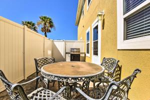 a patio with a table and chairs and a fence at Waterfront Corpus Christi Townhome with Pool and Dock! in Corpus Christi