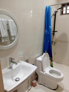 a bathroom with a sink and a toilet and a mirror at Kendwa Cool and Calm Hotel limited in Kendwa