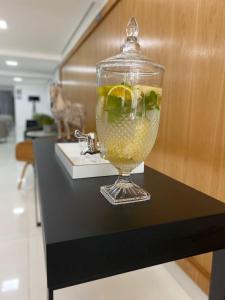 un jarrón de cristal lleno de líquido sobre una mesa en Logic Hotel Volta Redonda en Volta Redonda