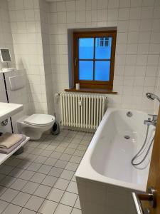 La salle de bains blanche est pourvue d'une baignoire et de toilettes. dans l'établissement Altstadtwohnung Kromers, à Erfurt