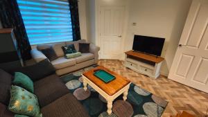 sala de estar con sofá y TV en Saxon Corner: BRAND NEW 3 bedroom House en Emsworth