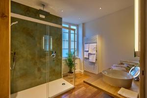 ein Badezimmer mit Badewanne und Glasdusche in der Unterkunft Appartement Montagnon - Les Suites du Palais - Classé 4 étoiles, parking privé, vue cathédrale, 3 chambres, PRIMO C0NCIERGERIE in Nevers