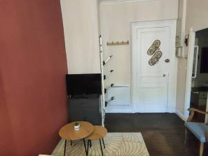 ein Wohnzimmer mit einem TV, einem Tisch und einer Tür in der Unterkunft Appartement Cauterets, 2 pièces, 4 personnes - FR-1-234-271 in Cauterets