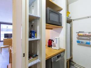 Dieses Zimmer verfügt über eine Küche mit einem Kühlschrank und einen TV. in der Unterkunft Appartement 6 pers, 1 chambre, balcons, plein centre station, proche pistes - La Mongie - FR-1-404-335 in La Mongie + 5 Fotos