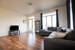 a living room with a couch and a television at The 1810 - Spacious with balcony - North of Quebec in Quebec City