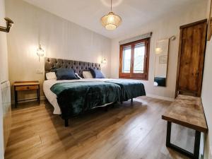 a bedroom with a large bed with a green blanket at La Granja Villa in La Granja de San Ildefonso