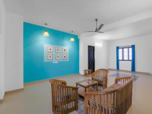 um quarto com uma mesa e cadeiras e uma parede azul em Goroomgo Dream LIne Kalikapur Kolkata em Calcutá