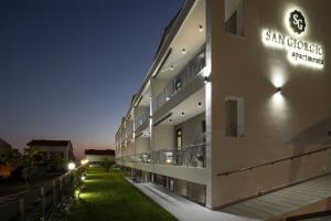 a building with a green lawn in front of it at San Giorgio Apartments Nikiti in Nikiti