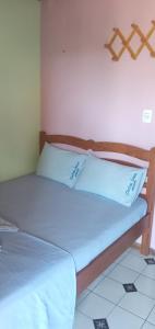 Una cama con dos almohadas blancas encima. en Chateu Soneca, en Algodoal