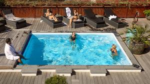 a group of people sitting in a swimming pool at Hotel Kirstine in Næstved
