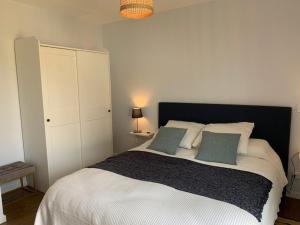 a bedroom with a large white bed with two pillows at Maison 3* à Trébeurden: jardin clos, 2 chambres, proche plage et sentiers - FR-1-542-46 in Trébeurden