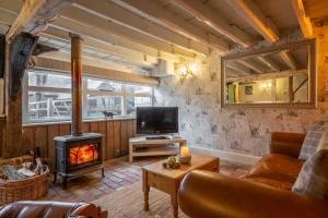 a living room with a fireplace and a couch at The Dairy at Green Valley Farm in Laxfield