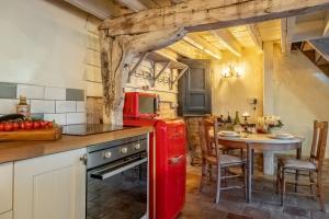 a red refrigerator in a kitchen with a table at The Dairy at Green Valley Farm in Laxfield