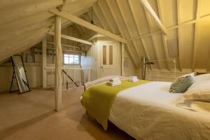 ein Schlafzimmer mit einem großen Bett im Dachgeschoss in der Unterkunft The Dairy at Green Valley Farm in Laxfield
