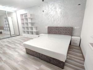 a bedroom with a large white bed and a wooden floor at Rika apartments in Chernivtsi