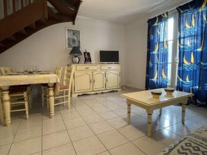 een woonkamer met een tafel en een televisie bij Appartement Saint-Martin-de-Ré, 3 pièces, 4 personnes - FR-1-246C-21 in Saint-Martin-de-Ré
