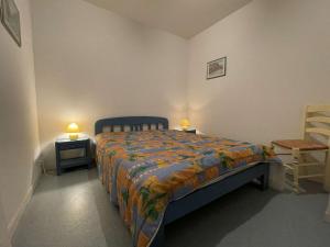 een slaapkamer met een bed en een stoel en 2 lampen bij Appartement Saint-Martin-de-Ré, 3 pièces, 4 personnes - FR-1-246C-21 in Saint-Martin-de-Ré