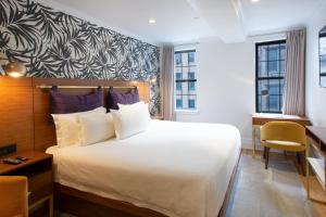 a hotel room with a large bed and a desk at Hotel Scherman in New York