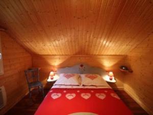 a bedroom with a red bed in a wooden room at chalet de montagne in Vagney