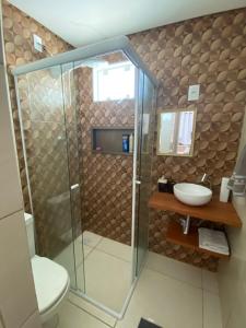 een badkamer met douche en wastafel bij Casa de Hóspedes com Piscina em Porto Belo in Porto Belo