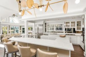 a kitchen with white cabinets and a large island at West End Splendor by Snowmass Vacations in Aspen