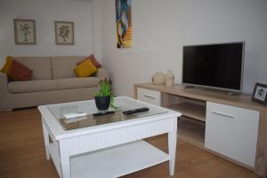 a living room with a tv and a white coffee table at Terreiro da Erva House 2 in Coimbra