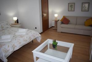 a living room with a bed and a table with a plant on it at Terreiro da Erva House 2 in Coimbra
